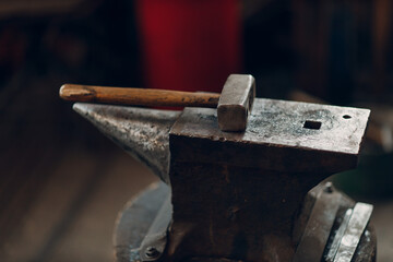 Blacksmith's hammer on metal anvil at forge. Overhead view