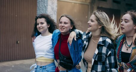 Slow motion stylish girls walking together on street talking laughing smiling having fun spending time together .