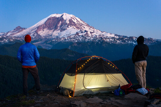 Portrait of two hikers with backpacking tent in front of Mt Rainier