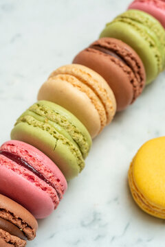 Above view of colorful macaroons on a marble background