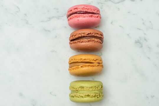 Above view of colorful macaroons on a marble background