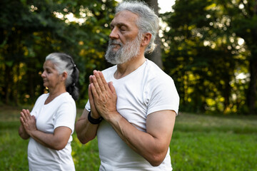 Senior man and woman are working out in the nature