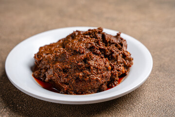 Beef Rendang is a Minang dish originating from the Minangkabau region in West Sumatra, Indonesia.  Rendang has been slow cooked and braised in a coconut milk seasoned with a herb and spice mixture