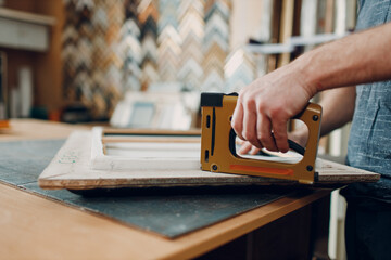 Framing Workshop assembling. Stapler ruler and frames baguette handmade picture frame at studio...