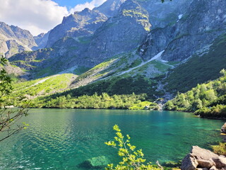 beautiful panorama - mountains, on a clear sunny day, reflected in the turquoise water of a mountain lake