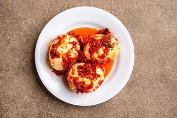 Indonesian Food Telur balado or boiled eggs with sambal balado. It is popular dish among Indonesia people. served in white plate
