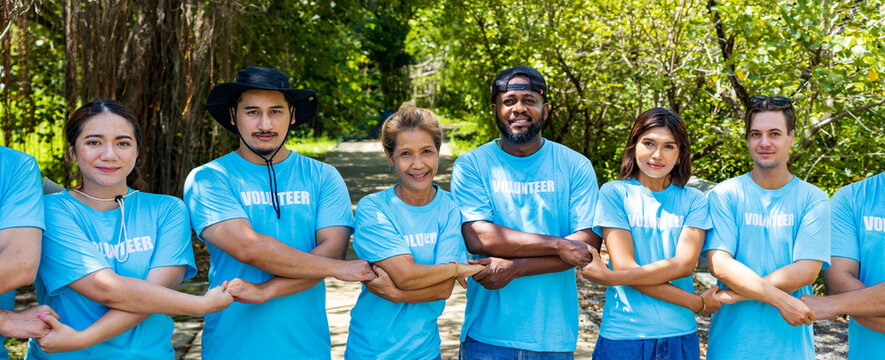 Team Of Young And Diversity Volunteer Workers Group Enjoy Charitable Social Work Outdoor In Mangrove Planting Project Wearing Blue T-shirt While Joining Hand In Assemble Unity Concept