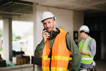 Contractor and architect looking at plan, tablet, laptop and talking about working on big project. Building in construction process interior. team work .