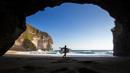 Silhouette photo of a woman dancing at Kelingking Beach, Nusa Penida, Bali taken from inside the...