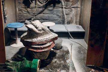 Artisan craftsman create mask based on plaster cast. Gypsum mold and plastic mask sculpting.