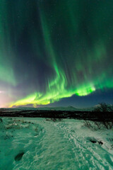 imagen de un paisaje nocturno natural nevado, con una aurora boreal en el cielo de Islandia  - obrazy, fototapety, plakaty