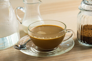 cup of hot Intense coffee dark shot in glass on wooden table with beans with crema. coffee beans and cup full of Intense dark shot coffee in glass cup