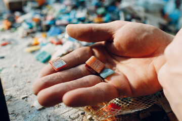 Man mosaics master chooses select smalt glass pieces for mosaic panel. Male mosaicist at work