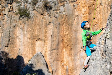 Fototapeta premium climber boy. the child trains in rock climbing.