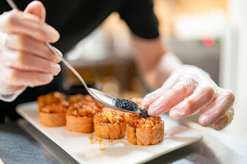 professional chef's hands making sushi roll in a restaurant kitchen