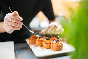 professional chef's hands making sushi roll in a restaurant kitchen