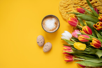 beautiful Easter frame mockup with tulips, eggs and a cup of coffee on a bright yellow background....