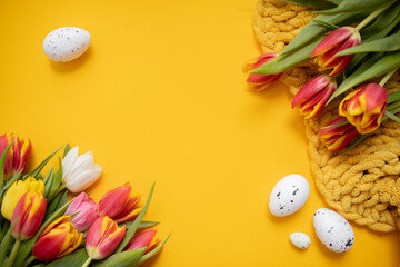 
beautiful easter frame mockup with tulips and painted eggs on bright yellow background. top view. copy space. flat lay