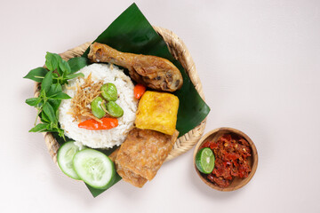 Nasi Liwet Sunda. A Traditional Sundanese Rice Served with Fried Chicken, Tofu, Tempeh, Anchovies, Chili and Broad Beans