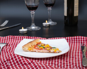 A glass of red wine with pizza on a cutting board.
Delicious homemade natural Italian-style whole wheat pizza with vegetables and cheese for a romantic dinner with wine.