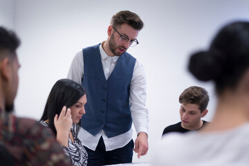 Teacher Giving Lesson to Diverse Multiethnic Group of Female and Male Students in College Room