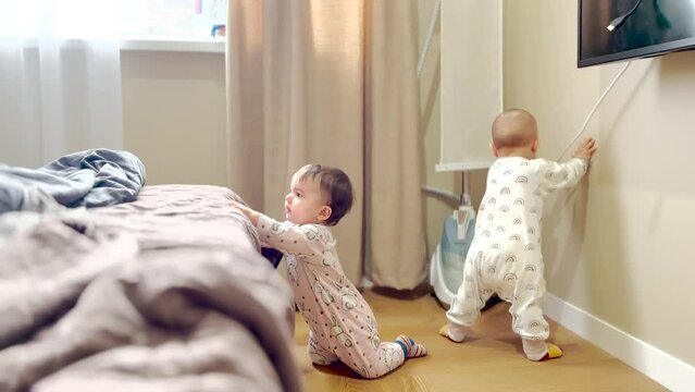 team of little explorers: baby a twins play are exploring steamer. childhood baby team family concept. baby twins play learn to explore new things. baby twins take apart the steamer fun in bedroom