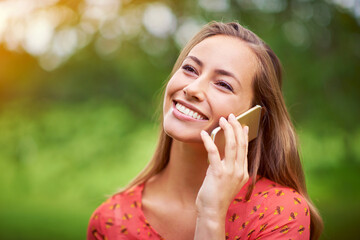 So good to hear from you. a young woman talking on her cellphone outside.