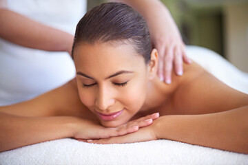 Obraz na płótnie Canvas Let your troubles drift away. a young woman enjoying a back massage at a spa.