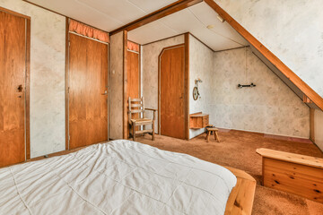 a bedroom with two wooden doors and a bed in the corner next to the door is a desk, chair and mirror