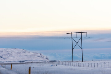 imagen de un poste de luz en un paisaje nevado y el cielo azul con nubes 