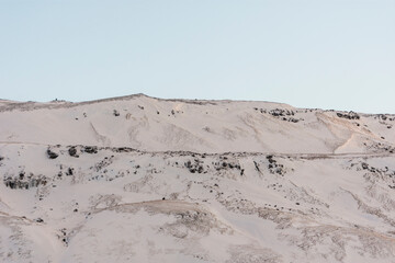 imagen detalle pico de una montaña nevada con el cielo azul de fondo 