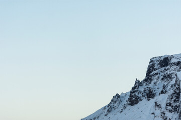 imagen detalle cima de una montaña nevada con el cielo azul de fondo 