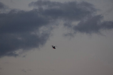 Rainy Clouds. A helicopter in a rainy cloudy sky covering the sun. Clouds Covering Sky.