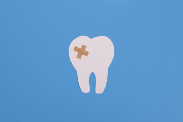 sealed white paper tooth sealed by a shepherd on a blue background. Dental treatment, dentist services concept
