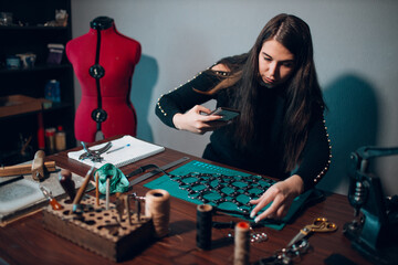 Tanner woman making leather harness take photo mobile cell phone on workshop. Working process of...