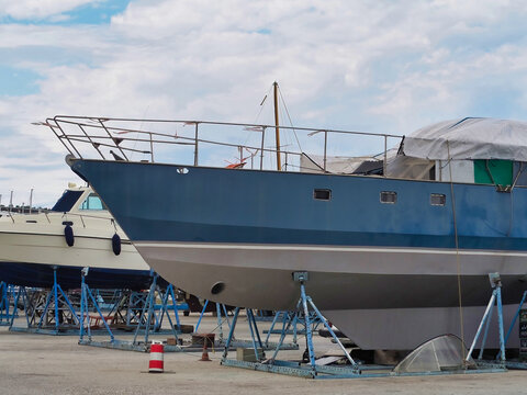 White blue sailboat beached for antifouling hull paint