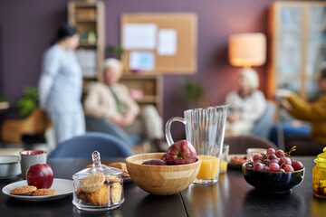 Background image of breakfast table with fruit and pastry at retirement home or assisted living...