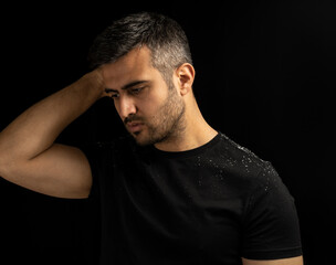 Close up low key portrait of man with dandruff or itchy hair problem. Concept of hair care, ...