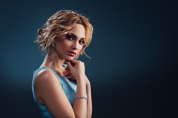 Young elegant blond woman in blue dress fashion portrait