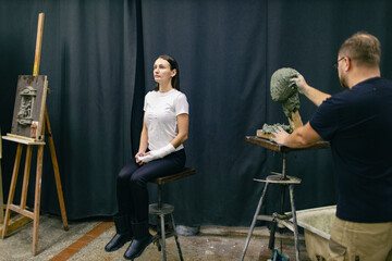 Man sculptor creates sculpt bust clay human woman sculpture. Statue craft creation workshop.