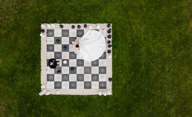 The bride and groom on the chessboard. A view of the chess set from above. Wedding photo. 