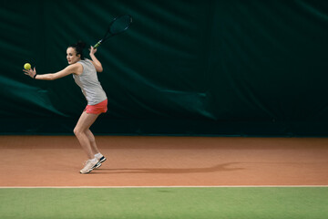 Tennis woman player playing training with racket and ball at court.