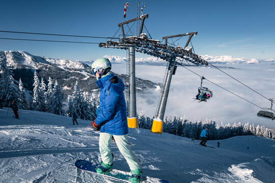 Female snowboarder going down a mountain on a sunny day