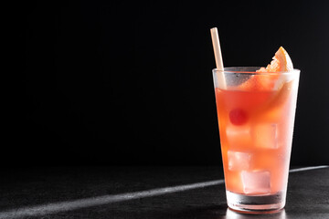 Sea breeze cocktail in glass on black background. Copy space