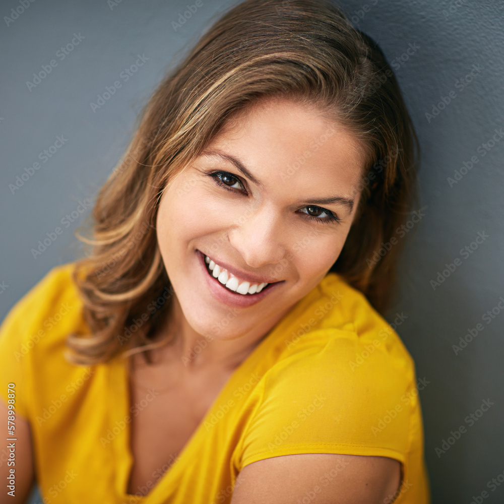 Wall mural Im in a great mood today. a young woman posing against a gray wall.