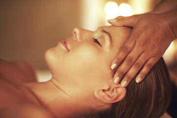 Relax and unwind. Closeup shot of a young woman enjoying a head massage at the spa.