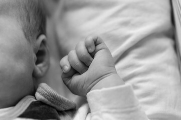 close up detail of a sleeping baby hand and ear