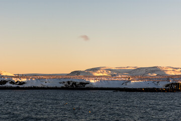 imagen de unas montañas nevadas con el cielo azul despejado de fondo y el mar en la parte inferior
