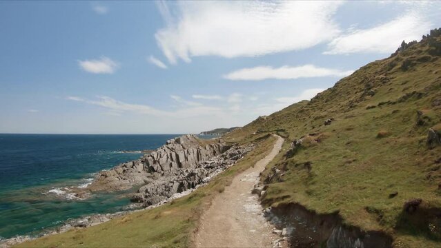 Walking along the trail, South West Coast path, Morte Point. Rocky coast near Woolacombe, Devon, UK. First person view. 