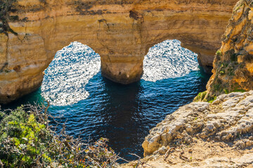 Heart shape made by rocks and plants at Marinha Beach in Algarve, Portugal